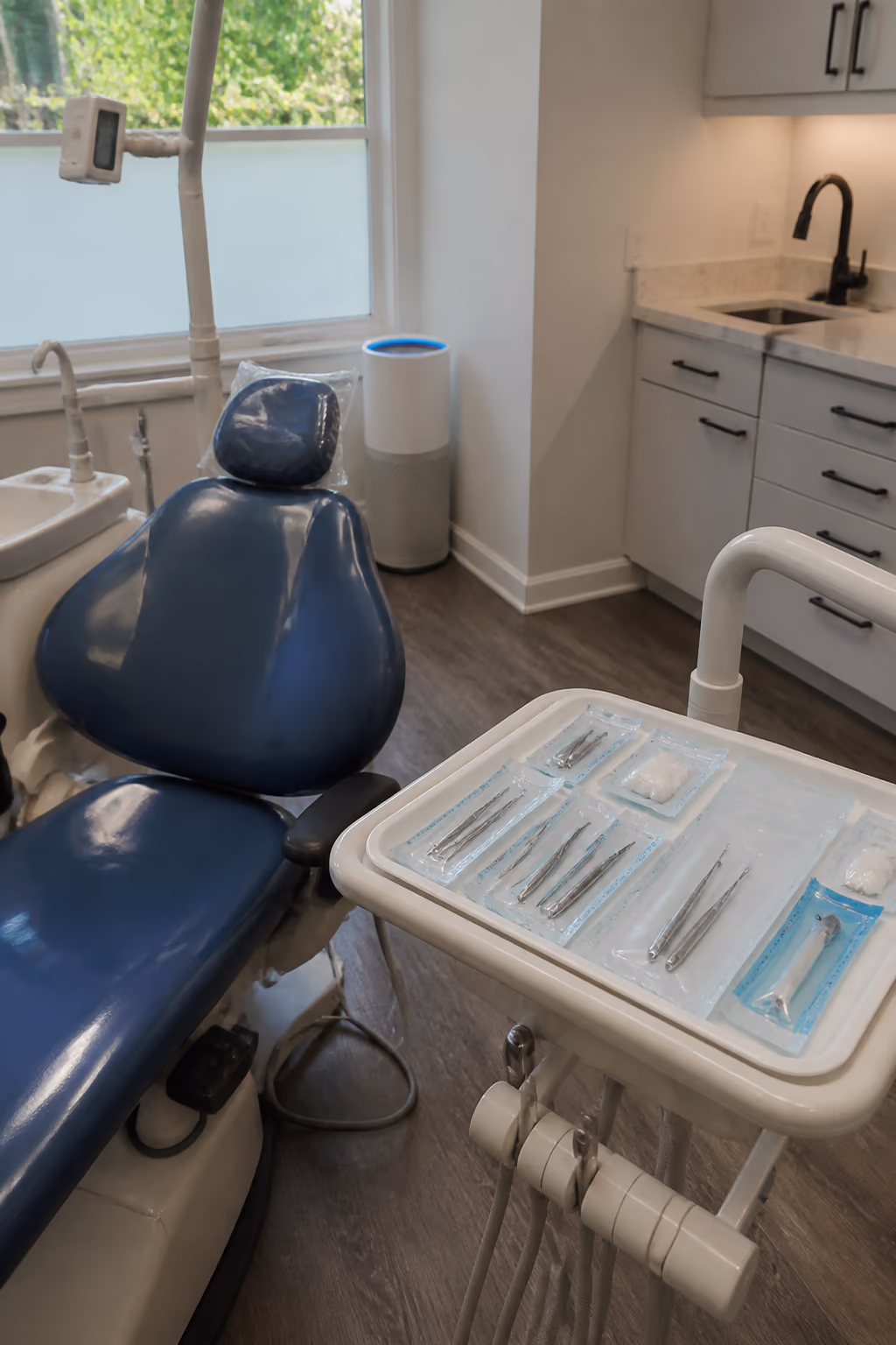 A prepared dental operatory in Ottawa with freshly disinfected chair surfaces, sealed clinical supply pouches and a HEPA air purifier standing in the corner.