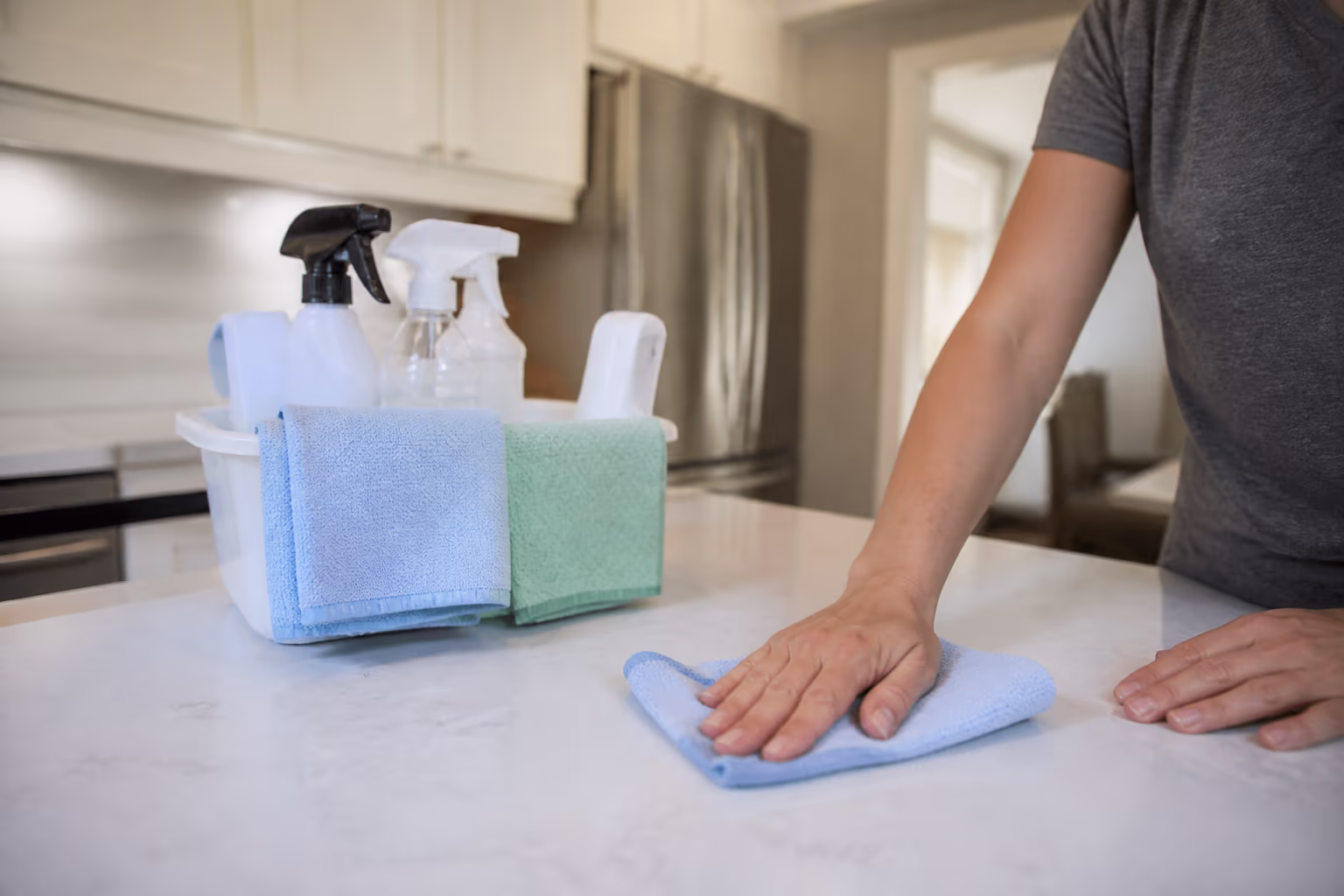 A landscape view of a supply caddy with fragrance-free cleaning products and fresh microfibre cloths on a bright Ottawa counter, representing a lower-residue professional home cleaning visit.
