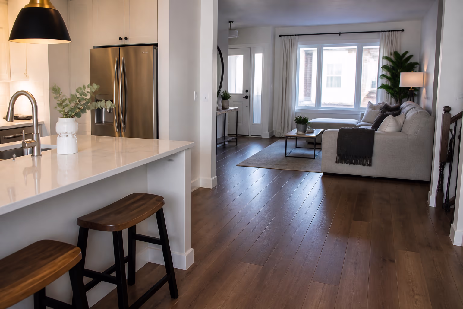 A landscape view of a freshly cleaned Ottawa home after a professional visit, with a tidy kitchen and living area, light across the floor and a final walkthrough in progress.