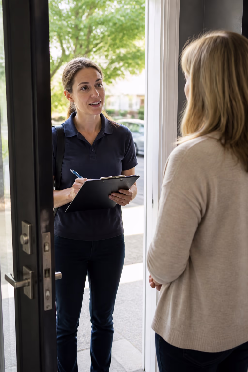 A portrait of a consultant at an Ottawa front door with a clipboard, confirming access, parking and the scope before the first visit.