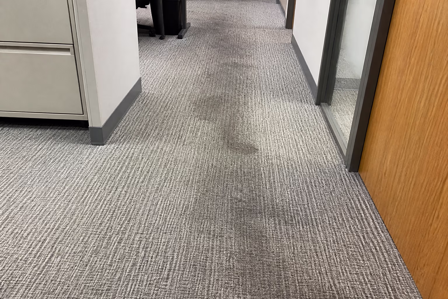A landscape view of an office carpet traffic path in Ottawa, showing the worn, ground-in finish that builds up when a cleaning routine is left too long.