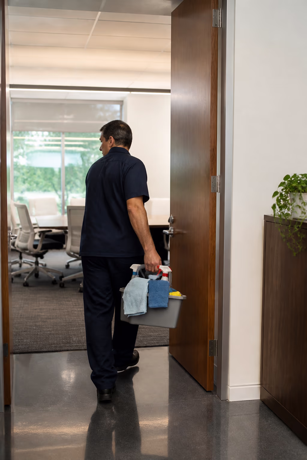 A portrait of a janitor moving between zones in a mixed-use commercial building in Ottawa, adapting the routine to the offices, washrooms and shared spaces of each floor.
