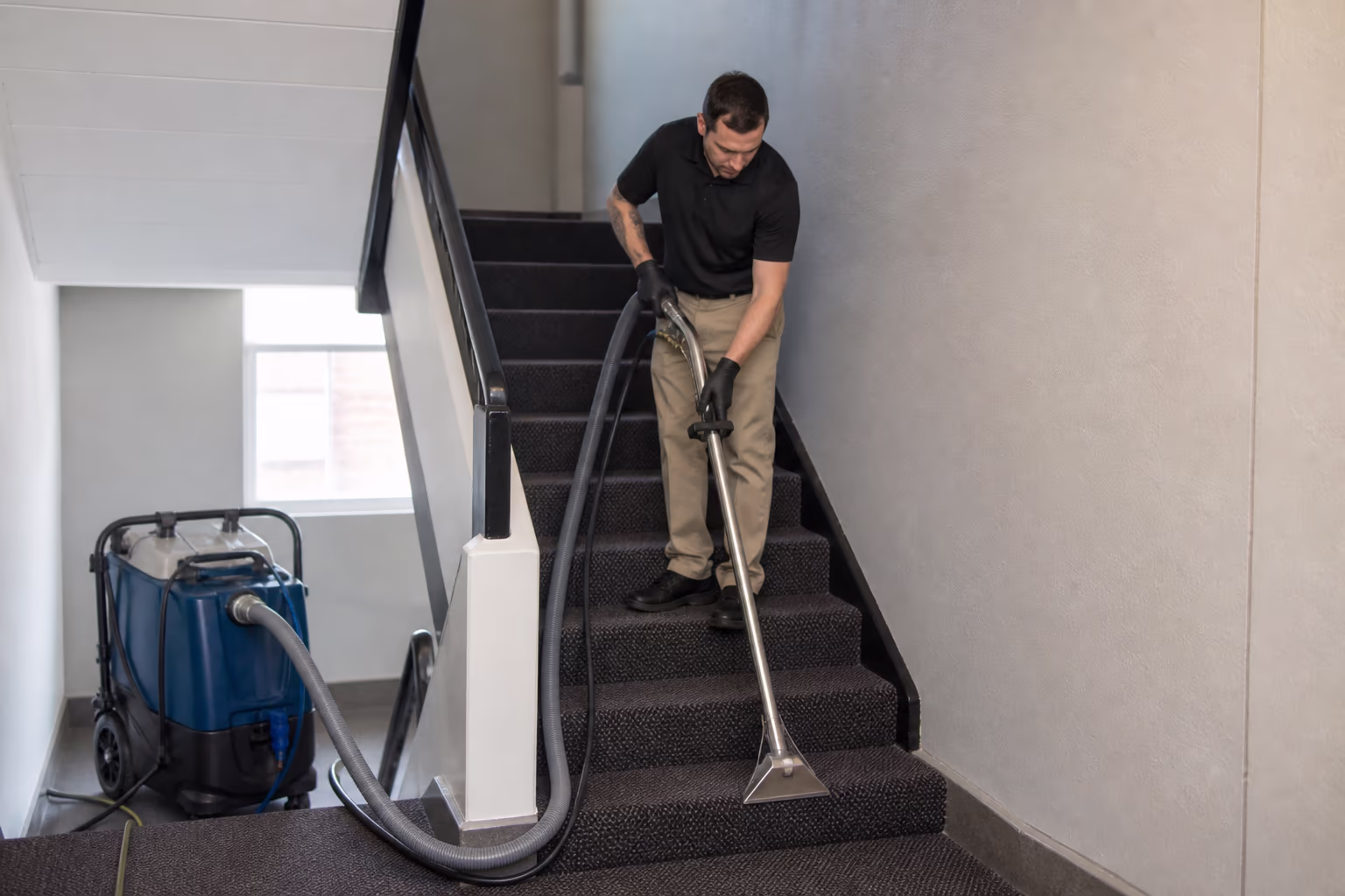 A landscape view of a professional team deep-cleaning a carpeted stairwell in an Ottawa building, extracting the ground-in soil that a daily routine cannot reach.