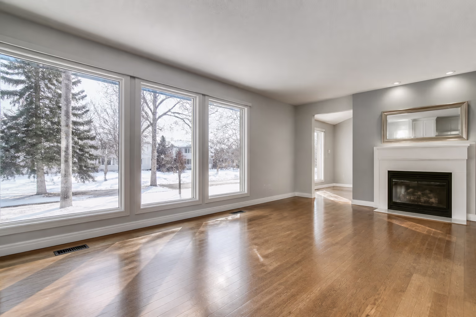 Empty living room with polished floors and clear windows, ready for the next occupant
