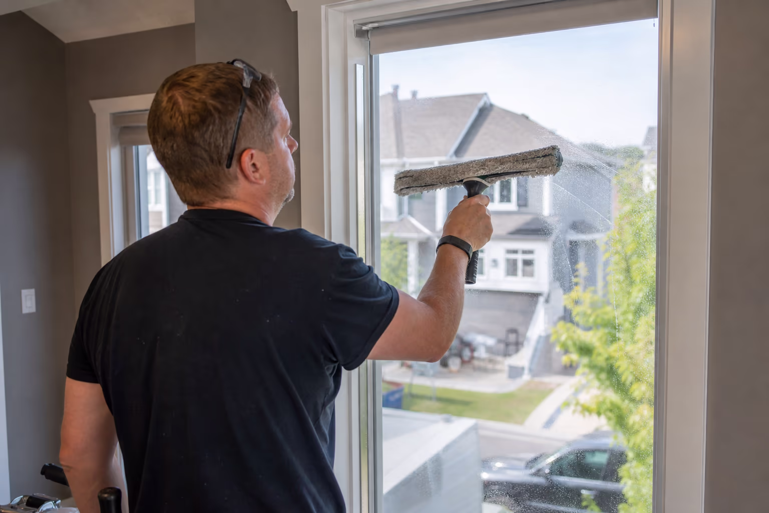 Cleaner working a home window from the inside, where access is agreed before the visit