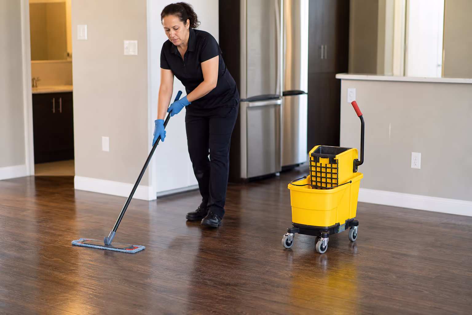 Mop and wheeled bucket resting on a clean floor